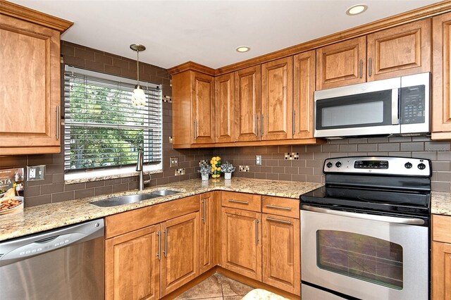 3985 Maceachen Blvd Unit 224, Sarasota, FL 34233 - kitchen with appliances with stainless steel finishes, tasteful backsplash, brown cabinetry, light stone countertops, and recessed lighting