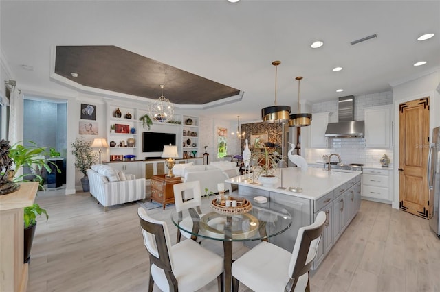 5469 Lampiasi St, Sarasota, FL 34238 - dining space featuring a raised ceiling, light wood-style flooring, ornamental molding, recessed lighting, and a chandelier