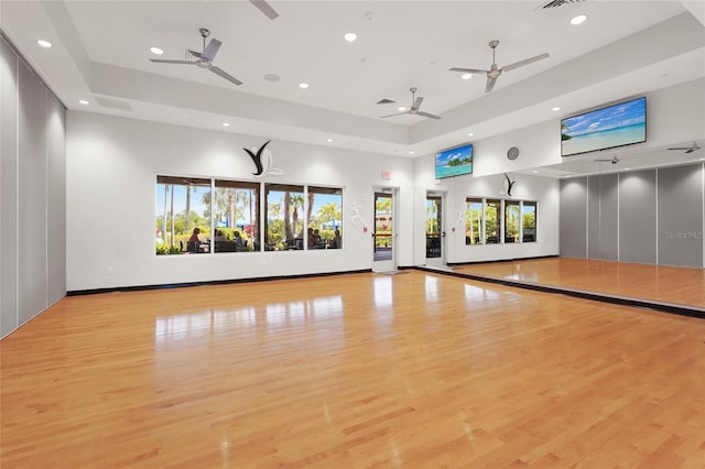 5469 Lampiasi St, Sarasota, FL 34238 - workout room featuring a tray ceiling, recessed lighting, ceiling fan, wood finished floors, and a towering ceiling
