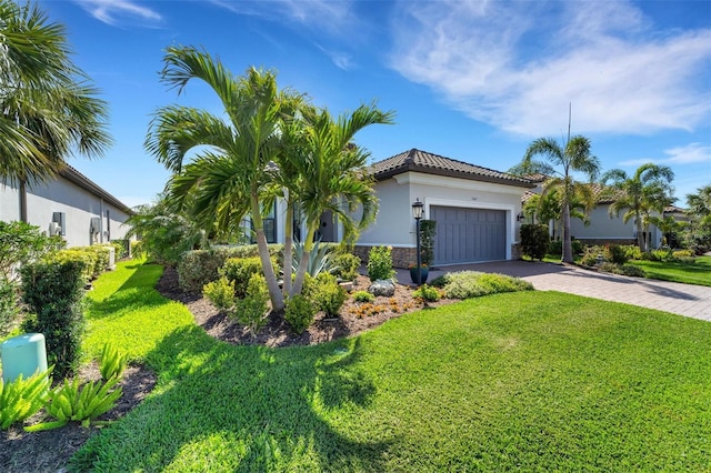 5469 Lampiasi St, Sarasota, FL 34238 - view of front facade featuring decorative driveway, stucco siding, a front lawn, a tile roof, and a garage