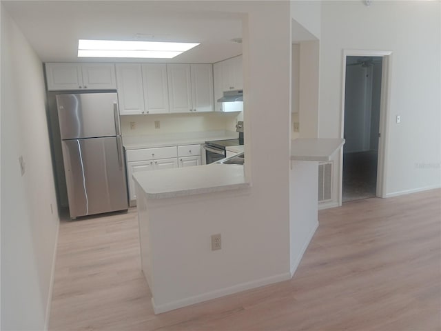4154 Center Pointe Cir Unit 57A, Sarasota, FL 34233 - kitchen with appliances with stainless steel finishes, light wood-style floors, light countertops, a peninsula, and under cabinet range hood