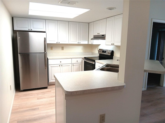 4154 Center Pointe Cir Unit 57A, Sarasota, FL 34233 - kitchen featuring appliances with stainless steel finishes, under cabinet range hood, light wood-style flooring, and white cabinetry