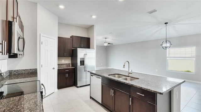 5327 Olano St, Palmetto, FL 34221 - kitchen with appliances with stainless steel finishes, a ceiling fan, dark stone counters, dark brown cabinetry, and decorative light fixtures