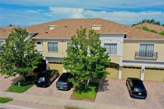 4026 Overture Cir Unit 487, Bradenton, FL 34209 - view of property with a garage, driveway, stucco siding, and roof with shingles
