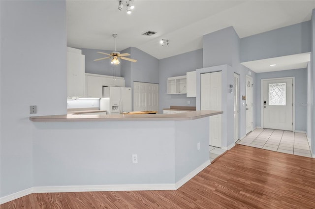 2417 Fairway Oaks Dr Unit 22, Palmetto, FL 34221 - kitchen featuring white fridge with ice dispenser, white cabinetry, a ceiling fan, light wood-style flooring, and high vaulted ceiling