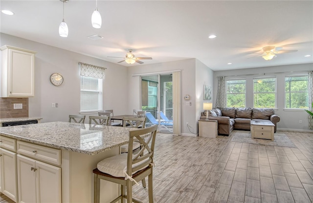 11625 Renaissance Blvd, Venice, FL 34293 - kitchen with ceiling fan, healthy amount of natural light, a breakfast bar area, open floor plan, and recessed lighting