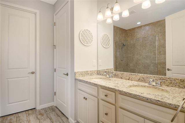 11625 Renaissance Blvd, Venice, FL 34293 - bathroom featuring double vanity, tiled shower, and wood finished floors