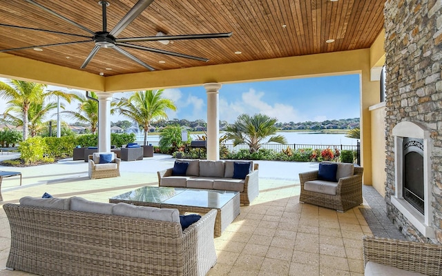 11625 Renaissance Blvd, Venice, FL 34293 - view of patio / terrace with an outdoor living space with a fireplace, ceiling fan, and a water view