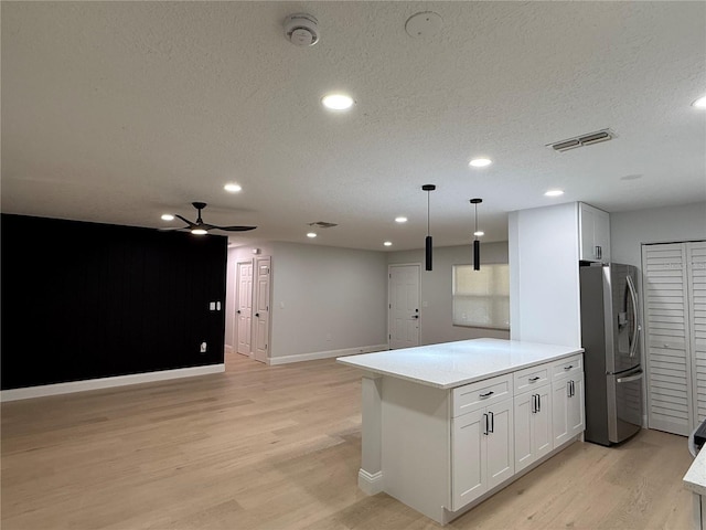 4661 Linwood St, Sarasota, FL 34232 - kitchen featuring stainless steel fridge, light wood finished floors, a ceiling fan, white cabinets, and a textured ceiling