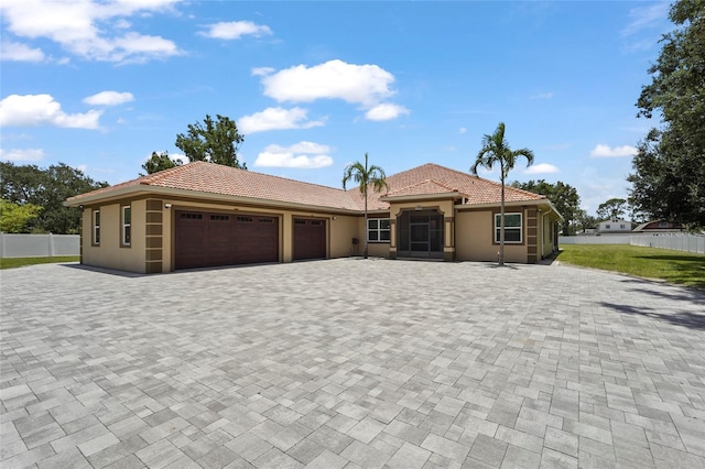 5714 38th Ave E, Bradenton, FL 34208 - view of front of home featuring an attached garage, a tile roof, driveway, and stucco siding