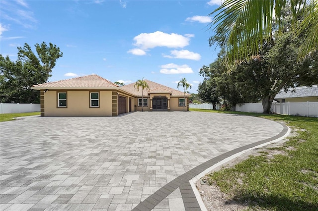 5714 38th Ave E, Bradenton, FL 34208 - view of front of property featuring decorative driveway, a garage, stucco siding, and a tiled roof