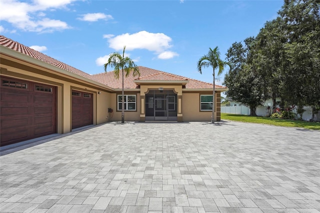 5714 38th Ave E, Bradenton, FL 34208 - view of front of home with an attached garage, stucco siding, a tile roof, and decorative driveway