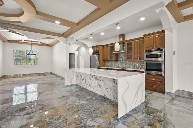 5714 38th Ave E, Bradenton, FL 34208 - kitchen featuring light marble finish floors, brown cabinets, arched walkways, stainless steel appliances, and recessed lighting
