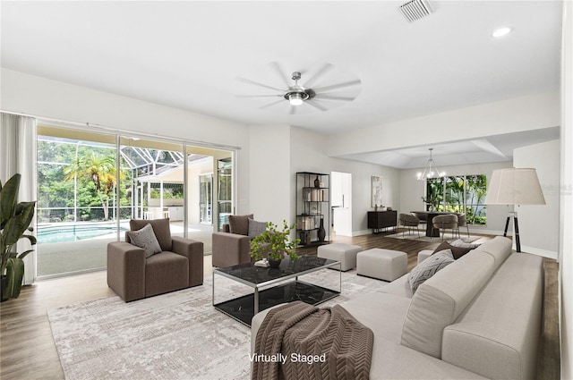 4724 White Tail Ln, Sarasota, FL 34238 - living room with wood finished floors, a ceiling fan, a sunroom, recessed lighting, and a chandelier