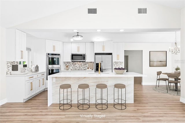 4724 White Tail Ln, Sarasota, FL 34238 - kitchen featuring stainless steel appliances, a kitchen breakfast bar, tasteful backsplash, recessed lighting, and high vaulted ceiling
