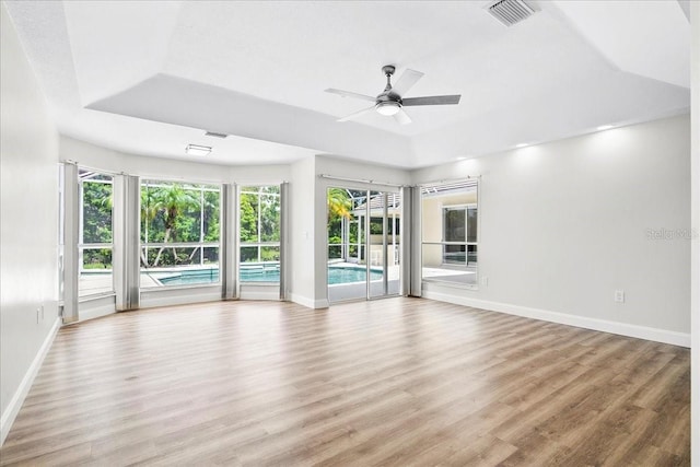 4724 White Tail Ln, Sarasota, FL 34238 - unfurnished room with a tray ceiling, light wood finished floors, healthy amount of natural light, and ceiling fan