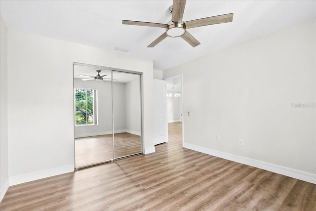 4724 White Tail Ln, Sarasota, FL 34238 - unfurnished bedroom featuring light wood-style floors, a closet, ceiling fan, and a chandelier