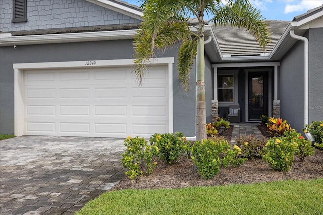 12349 Asana Ct, Venice, FL 34293 - entrance to property featuring decorative driveway, a garage, and stucco siding