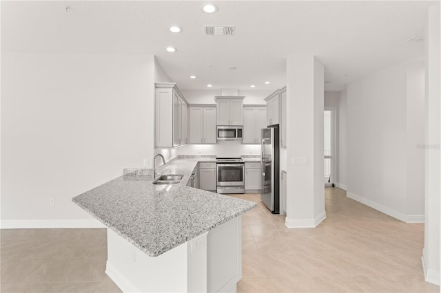 7611 34th Ave W Unit 301, Bradenton, FL 34209 - kitchen with stainless steel appliances, a peninsula, light stone countertops, light tile patterned flooring, and recessed lighting