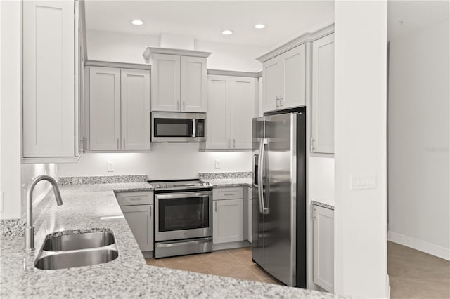 7611 34th Ave W Unit 301, Bradenton, FL 34209 - kitchen with appliances with stainless steel finishes, light tile patterned floors, recessed lighting, light stone countertops, and gray cabinetry