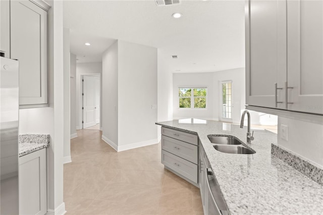 7611 34th Ave W Unit 301, Bradenton, FL 34209 - kitchen with stainless steel fridge, gray cabinetry, light stone countertops, recessed lighting, and light tile patterned flooring