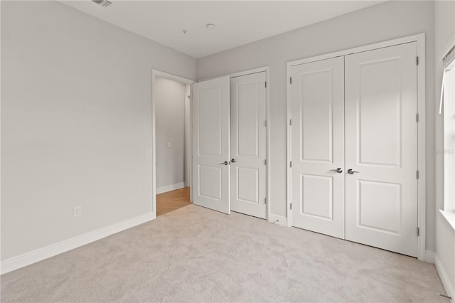 7611 34th Ave W Unit 301, Bradenton, FL 34209 - unfurnished bedroom with light carpet and multiple closets