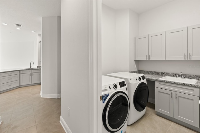 7611 34th Ave W Unit 301, Bradenton, FL 34209 - laundry area featuring washing machine and clothes dryer, cabinet space, and light tile patterned floors