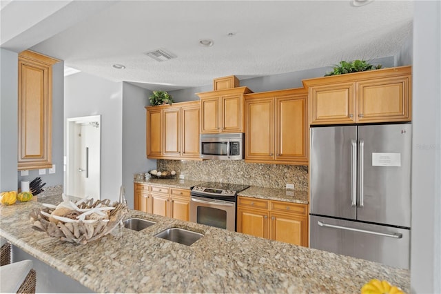 7611 34th Ave W Unit 301, Bradenton, FL 34209 - kitchen with appliances with stainless steel finishes, tasteful backsplash, light stone countertops, a textured ceiling, and recessed lighting