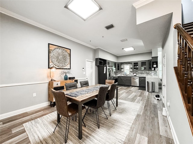 25640 State Road 70 E, Myakka City, FL 34251 - dining space with light wood-style flooring, ornamental molding, and stairway