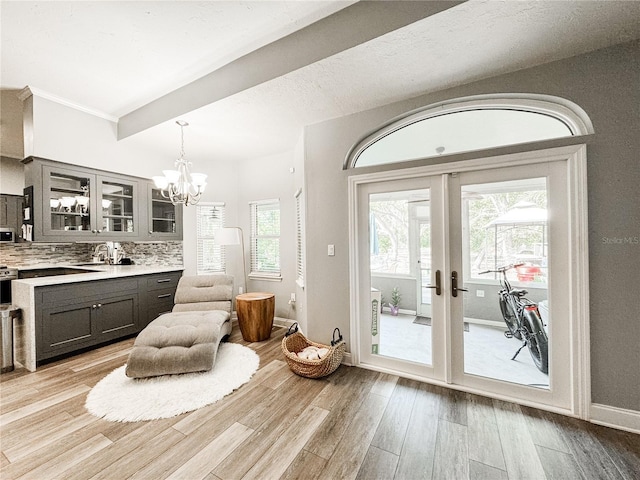 25640 State Road 70 E, Myakka City, FL 34251 - kitchen with light countertops, glass insert cabinets, a chandelier, light wood-style floors, and plenty of natural light