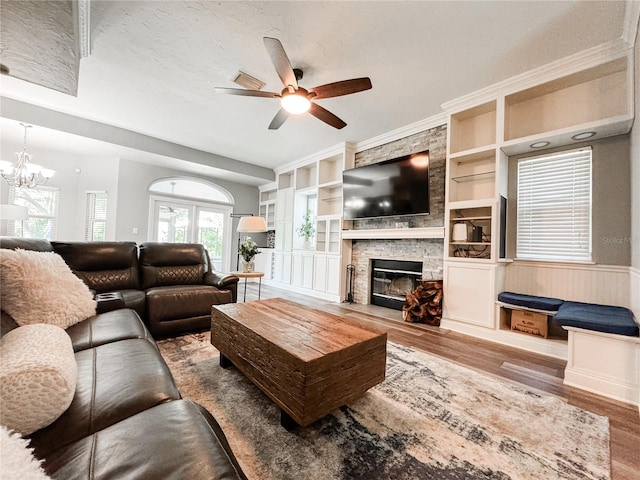 25640 State Road 70 E, Myakka City, FL 34251 - living area featuring wood finished floors, a fireplace, a ceiling fan, built in shelves, and a chandelier