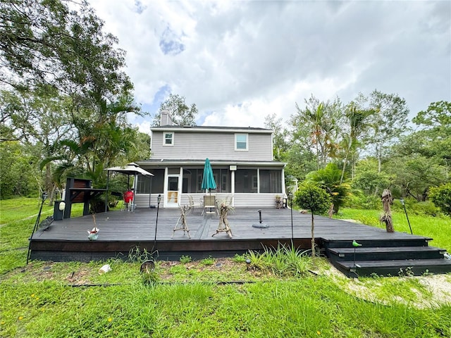 25640 State Road 70 E, Myakka City, FL 34251 - rear view of house with a sunroom, a chimney, a wooden deck, and a yard