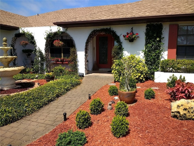 8703 53rd Ave W, Bradenton, FL 34210 - view of exterior entry featuring stucco siding and a shingled roof