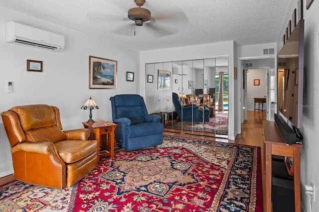 8703 53rd Ave W, Bradenton, FL 34210 - living room with an AC wall unit, wood finished floors, a ceiling fan, and a textured ceiling