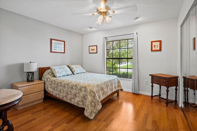 8703 53rd Ave W, Bradenton, FL 34210 - bedroom with light wood finished floors, a textured ceiling, and ceiling fan
