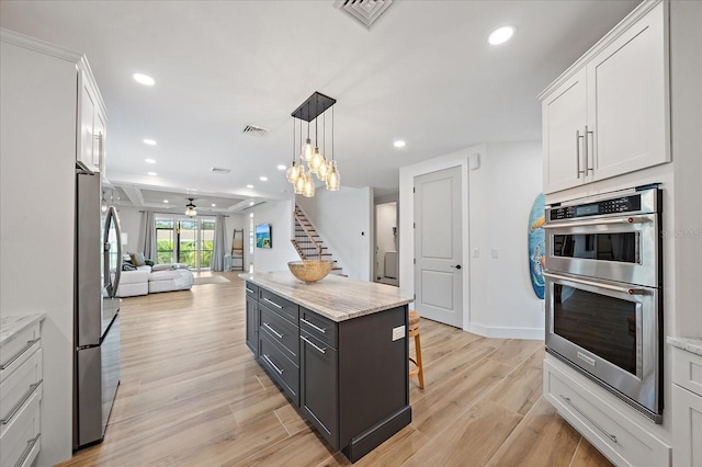1876 Livingstone St, Sarasota, FL 34231 - kitchen featuring stainless steel appliances, open floor plan, white cabinetry, ceiling fan, and light wood finished floors