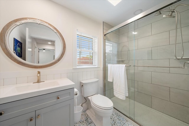 1876 Livingstone St, Sarasota, FL 34231 - bathroom featuring vanity, a stall shower, ceiling fan, wainscoting, and tile patterned flooring