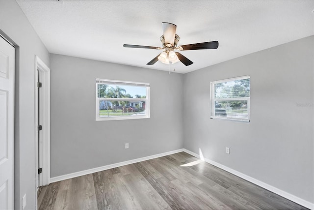 3327 King Blvd, Sarasota, FL 34234 - unfurnished bedroom with multiple windows, wood finished floors, and ceiling fan