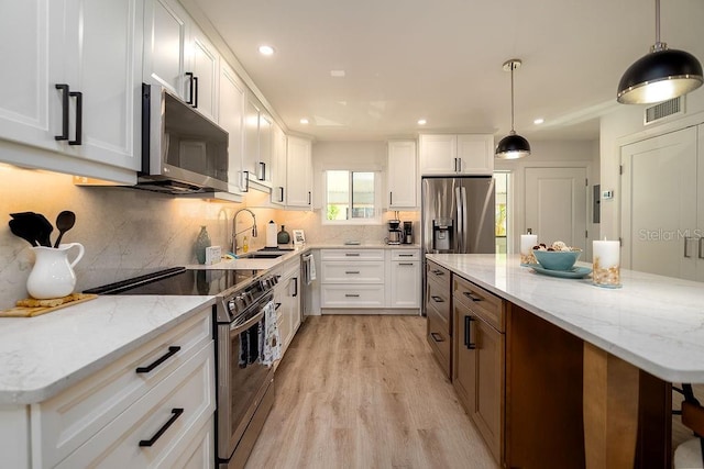 1801 Gulf Dr N Unit 276, Bradenton Beach, FL 34217 - kitchen with stainless steel appliances, light wood finished floors, white cabinets, backsplash, and recessed lighting