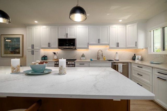 1801 Gulf Dr N Unit 276, Bradenton Beach, FL 34217 - kitchen with appliances with stainless steel finishes, white cabinetry, tasteful backsplash, light stone counters, and recessed lighting