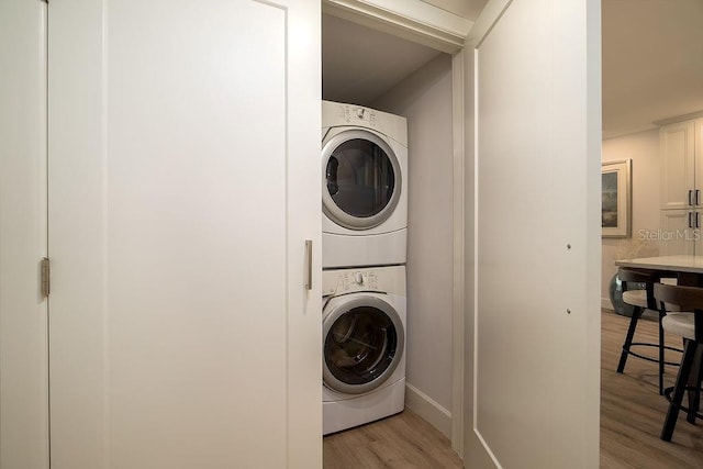 1801 Gulf Dr N Unit 276, Bradenton Beach, FL 34217 - washroom featuring stacked washer / dryer and light wood-style flooring