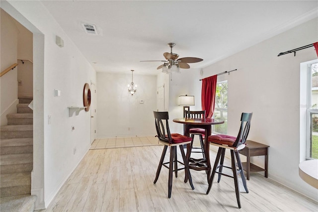 2303 28th Ave E, Palmetto, FL 34221 - dining space with light wood-type flooring, stairs, and ceiling fan