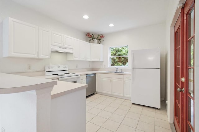 2303 28th Ave E, Palmetto, FL 34221 - kitchen with white appliances, under cabinet range hood, a peninsula, light tile patterned floors, and light countertops