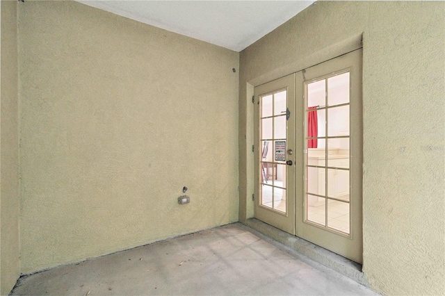 2303 28th Ave E, Palmetto, FL 34221 - unfurnished room featuring french doors, concrete flooring, and a textured wall