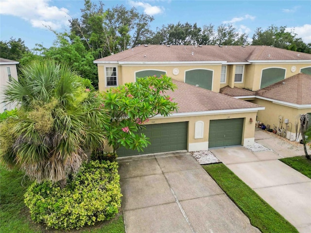 2303 28th Ave E, Palmetto, FL 34221 - view of front of house featuring concrete driveway, stucco siding, a garage, and a shingled roof