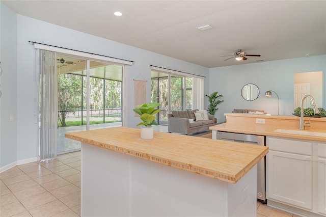 5405 98th Ave E, Parrish, FL 34219 - kitchen with stainless steel dishwasher, a ceiling fan, a kitchen island, white cabinets, and wooden counters