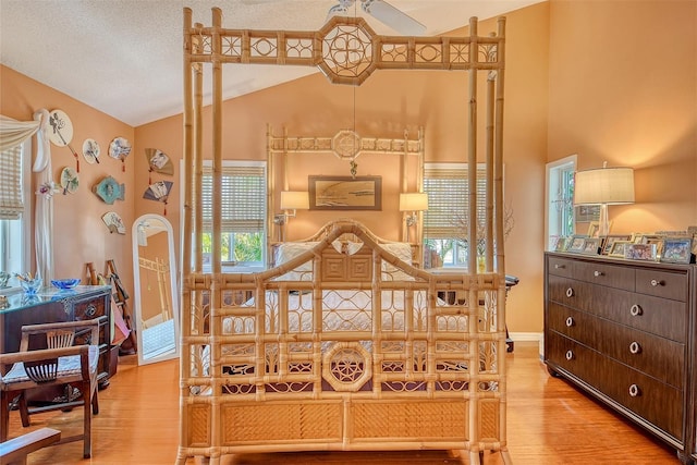701 Marbury Ln, Longboat Key, FL 34228 - bedroom with vaulted ceiling, wood finished floors, and multiple windows