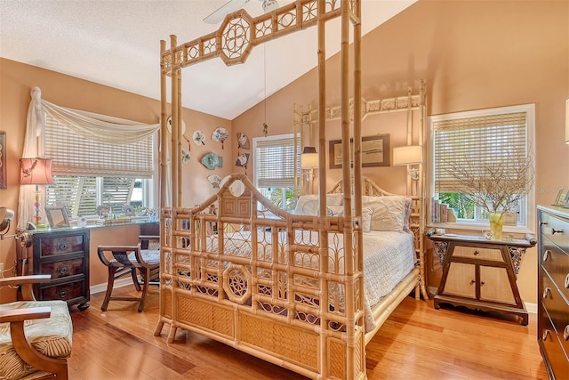 701 Marbury Ln, Longboat Key, FL 34228 - bedroom with light wood-style flooring, multiple windows, high vaulted ceiling, and a desk