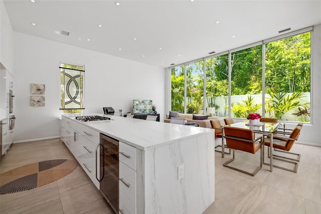 904 Virginia Dr, Sarasota, FL 34234 - kitchen featuring modern cabinets, white cabinets, wine cooler, gas cooktop, and light tile patterned floors