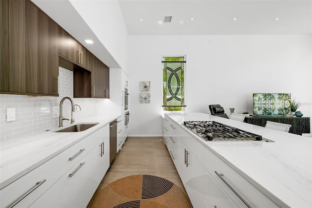 904 Virginia Dr, Sarasota, FL 34234 - kitchen featuring stainless steel appliances, decorative backsplash, light stone countertops, white cabinets, and recessed lighting